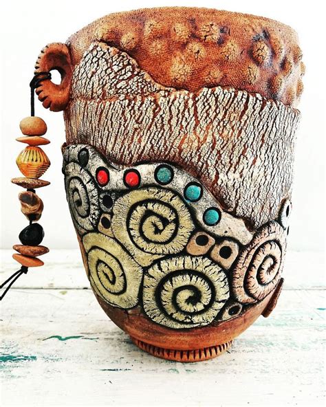 A Ceramic Vase Is Decorated With Beads And Wood