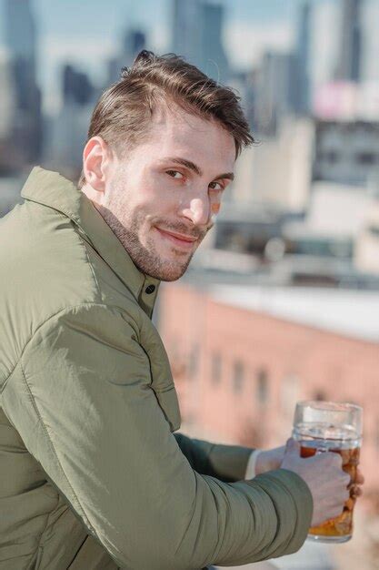 Premium Photo A Man Holding A Glass Of Beer And Smiling