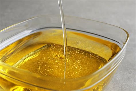 Pouring Cooking Oil Into Bowl On Light Background Closeup Stock Image