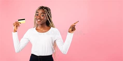 Black Woman Holding Credit Card And Pointing At Free Space Stock Photo