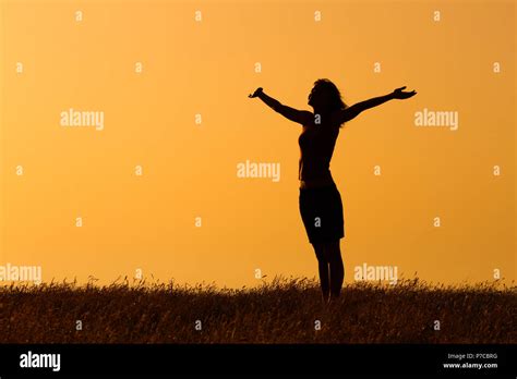 Silhouette of a woman with her arms outstretched Stock Photo - Alamy