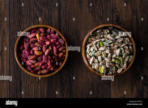 Raw And Roasted Wooden Bowl Of Peeled Pistachios Without Shell With