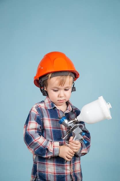 Heureux Petit Garçon Caucasien Portant Un Casque Tenant Un Pistolet