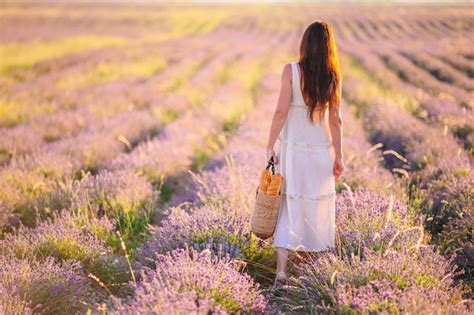 Mujer En Campo De Flores De Lavanda Al Atardecer En Vestido Blanco Y