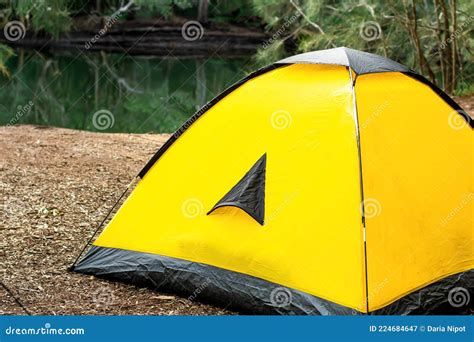 Yellow Tent At The Campsite Surrounding By Nature On The River Bank