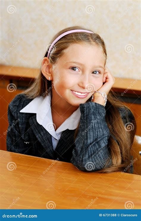 La Colegiala Se Sienta En Un Escritorio De La Escuela Foto De Archivo Imagen De Alegre