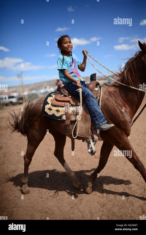 Cute young native american girl riding her horse during Navajo Nation Fair, a world-renowned ...