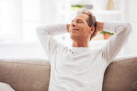 Enjoying Free Time At Home Cheerful Mature Man Holding Hands Behind