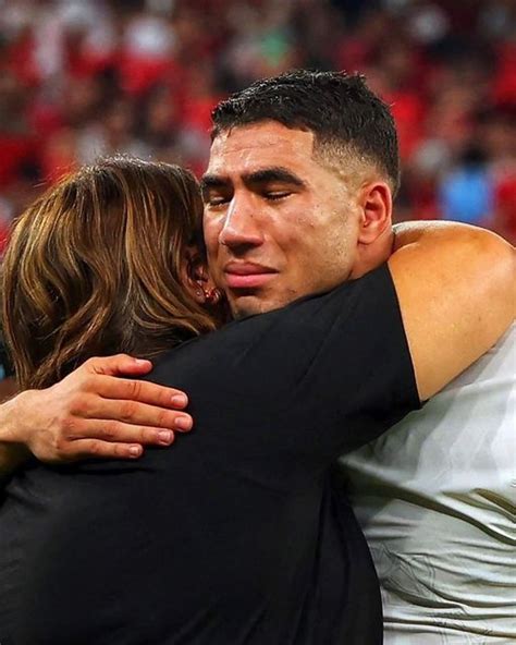 Two People Hugging Each Other In Front Of A Crowd At A Sporting Event