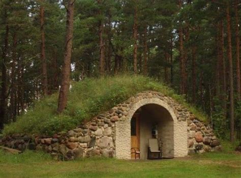 A Small Stone Structure With Grass On Top In The Middle Of A Forest