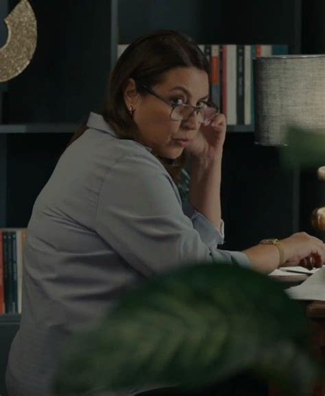 A Woman Sitting At A Desk In Front Of A Laptop Computer