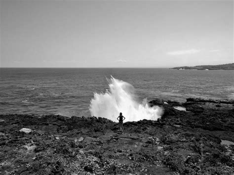 Premium Photo Rear View Of Woman Looking At Sea While Standing On Rocky Beach Against Sky