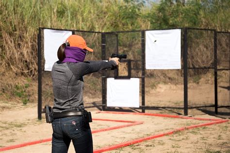 Premium Photo Woman Aiming Pistol In Shooting Range