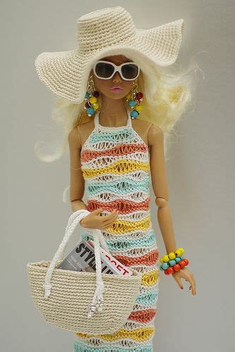 A Doll With Sunglasses And A Hat Holding A Purse In Her Hand While