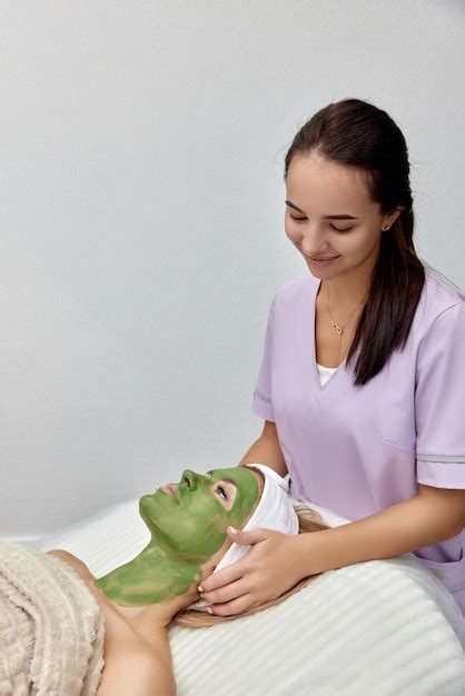 Premium Photo Female Beautician Applies The Mask To The Face Of