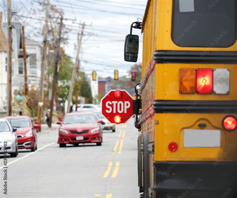 school bus with stop sign flashing on the street Stock Photo | Adobe Stock