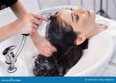 Hairdresser Washing Client S Hair In Modern Basin In Hairdressing