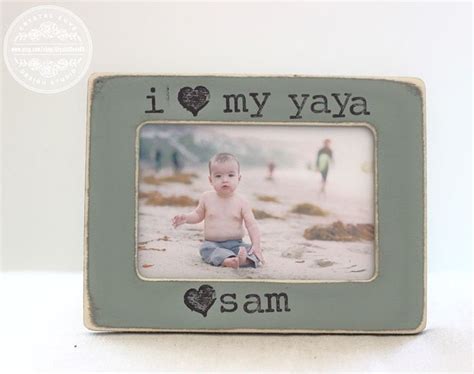 a baby sitting on the ground in front of a frame that says i love my yaya sam