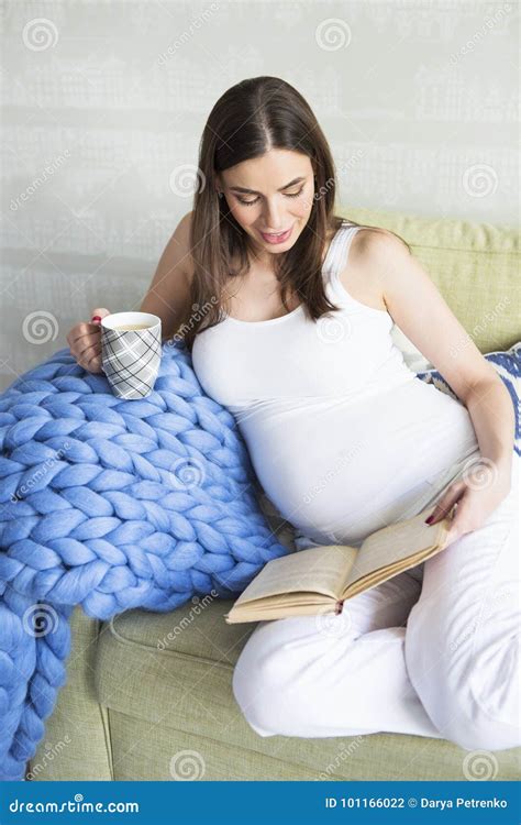 Femme Assez Enceinte De Jeunes S Asseyant Sur Le Sofa Photo Stock