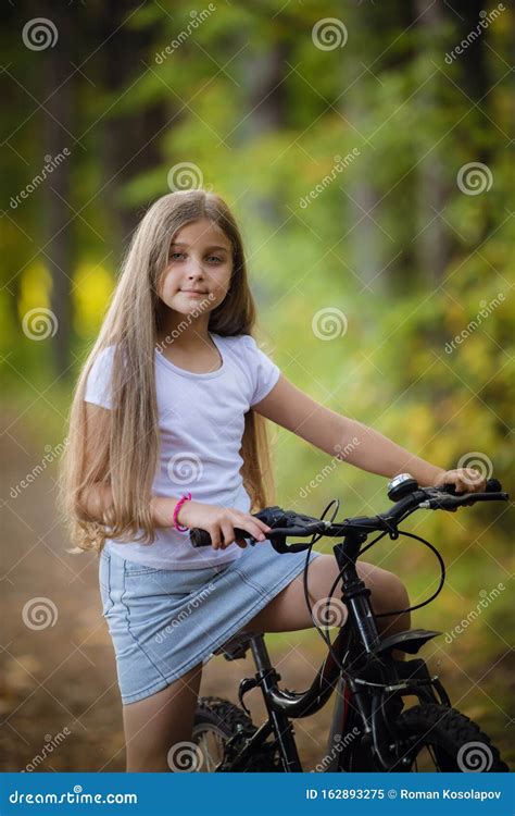 Ni A Adolescente Cortada Montando Bicicleta En Un Parque Soleado Imagen