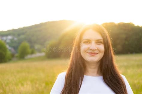 30 Year Old Brunette Woman With Long Hair Wearing Sunglasses In Nature