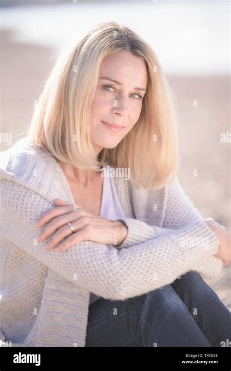 Portrait Of Smiling Mature Woman Sitting Outdoors Stock Photo Alamy