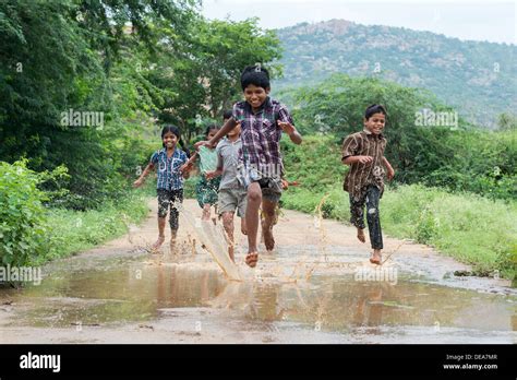 Rural Indian Village Children Running Through A Muddy Puddle Andhra