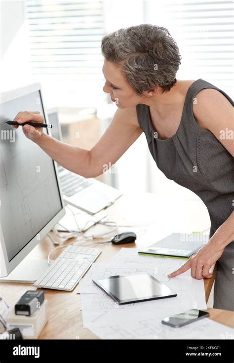 Adding A Few Details A Mature Female Architect Working On Building