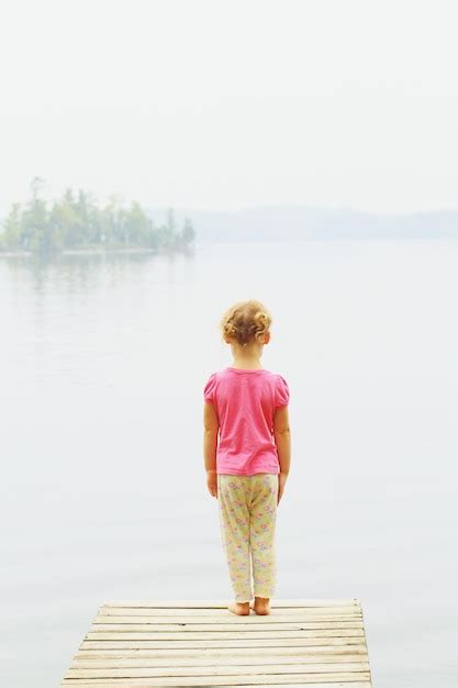 Premium Photo Rear View Of Girl Standing On Pier Over Lake