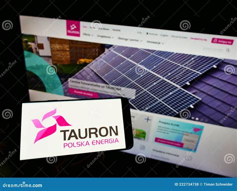 Person Holding Cellphone With Logo Of Polish Energy Company Tauron