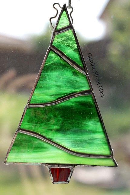 A Stained Glass Christmas Tree Ornament Hanging From A Window