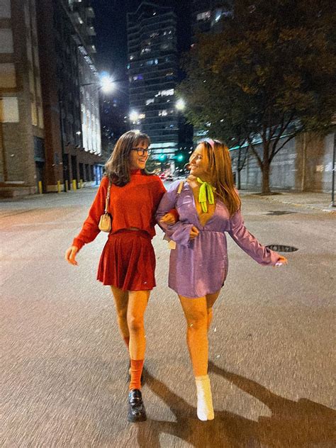 Two Girls Sdressed As Daphne And Velma Walking In The Street At Night