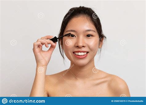 Happy Korean Lady Applying Makeup Using Mascara Enjoying Beauty