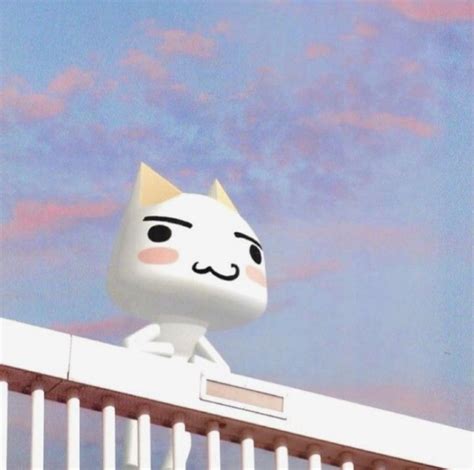 A White Cat Sitting On Top Of A Building With Clouds In The Sky Behind It