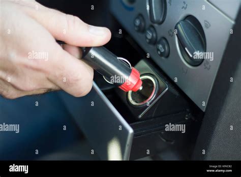 Hand Inserts The Plug Into The 12V Socket From The Car S Cigarette