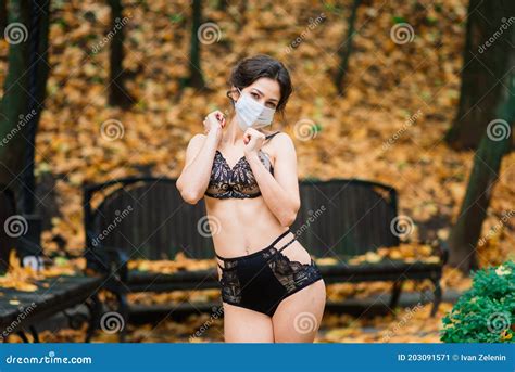 Fashion Portrait Of Woman In Mask And Lingerie In Autumn Park Pandemic Virus Coronavirus