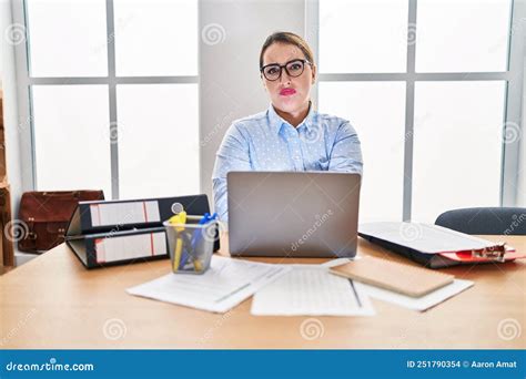 Young Hispanic Woman Working At The Office Wearing Glasses Skeptic And Nervous Disapproving