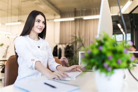 Side View Portrait Of Businesswoman Using Computer At Office Desk Stock