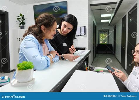 Smiling Female Patient Asking Her Dentist About Dental Treatment