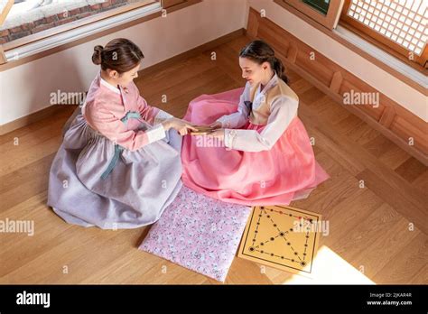 Korean And Caucasian Girls Wearing Hanbok Playing Yut Korean