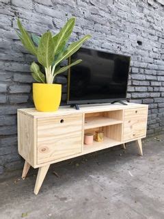 A Television Stand With A Potted Plant Next To It On The Side Of A