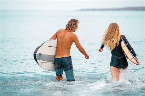 Premium Photo Surfers At The Beach Smiling Couple Of Surfers Walking