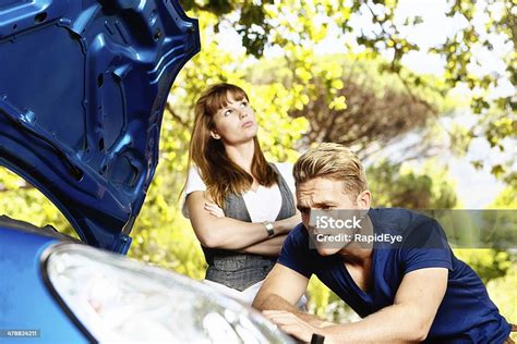 Young Woman Irritated By Mans Failure To Fix Her Car Stock Photo