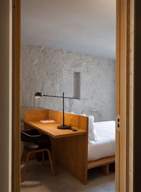 An Open Door Leading To A Bedroom With A Bed And Desk In The Middle Of It