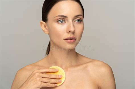 Female With Nude Make Up And Bare Shoulders Cleaning Her Body With
