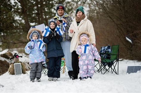 Familia finlandesa con banderas de finlandia en un agradable día de