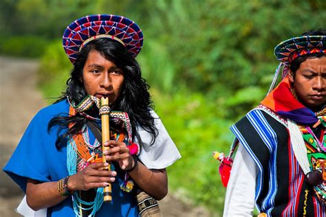 A Native From The Kamentsá Tribe Wearing A Colorful Headgear Plays