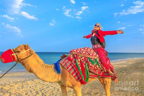 Woman riding camel Photograph by Benny Marty