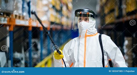 Man Worker With Protective Mask And Suit Disinfecting Industrial