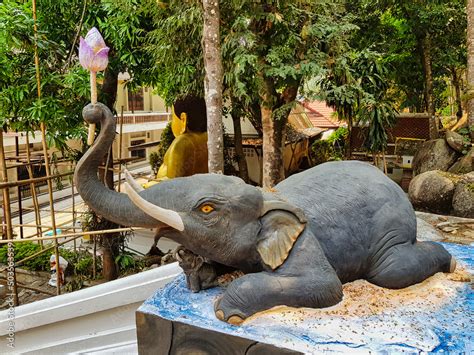 Sculpture Of An Elephant Lying Down With A Lotus Flower In Its Trunk